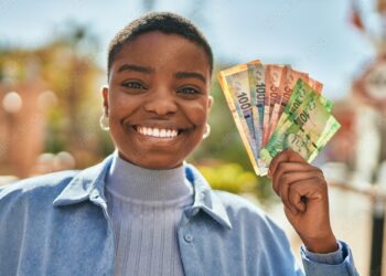 Young african american woman smiling happy holding south africa rand banknotes at the city.