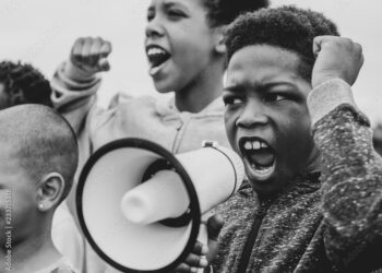 Young boy shouting on a megaphone in a protest