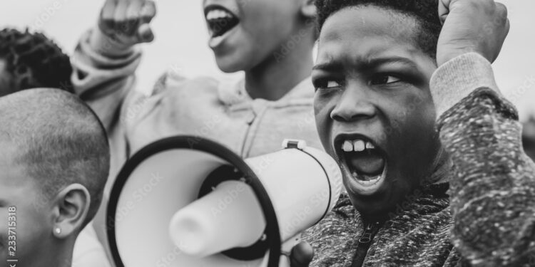 Young boy shouting on a megaphone in a protest